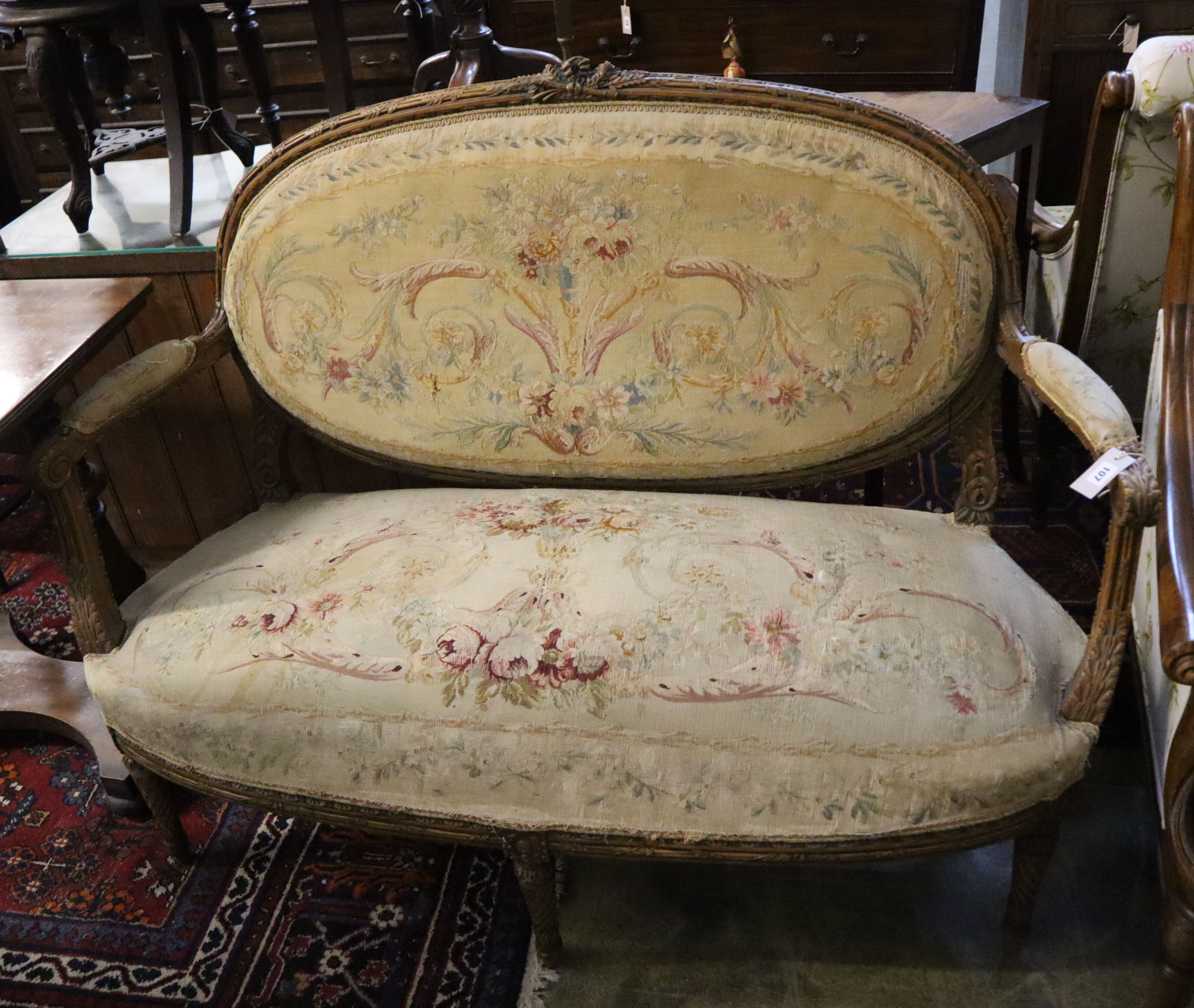 A Louis XVI style carved walnut (?) canape with Aubusson-style upholstery, length 144cm, 104cm high